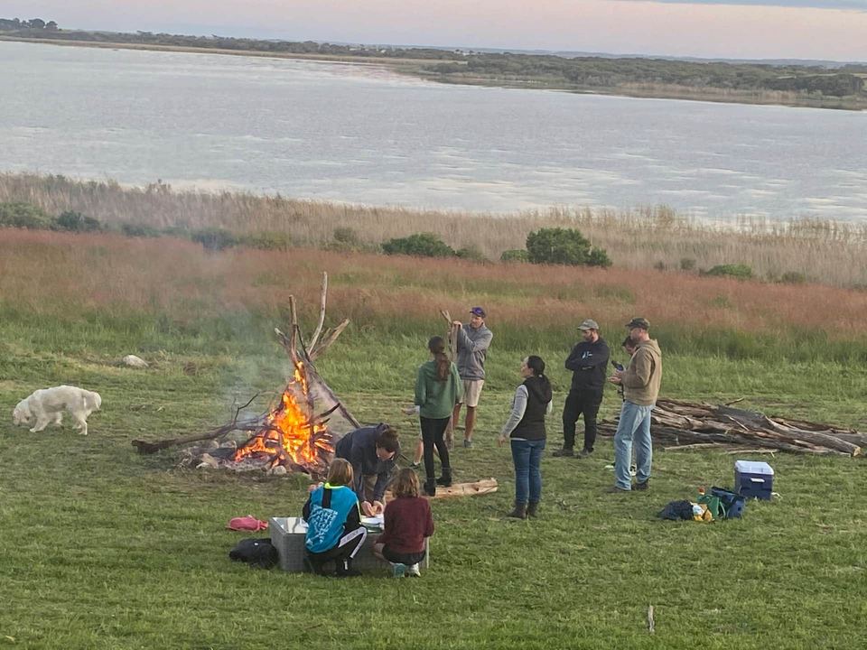 Friends gathered around the campfire on the lawn