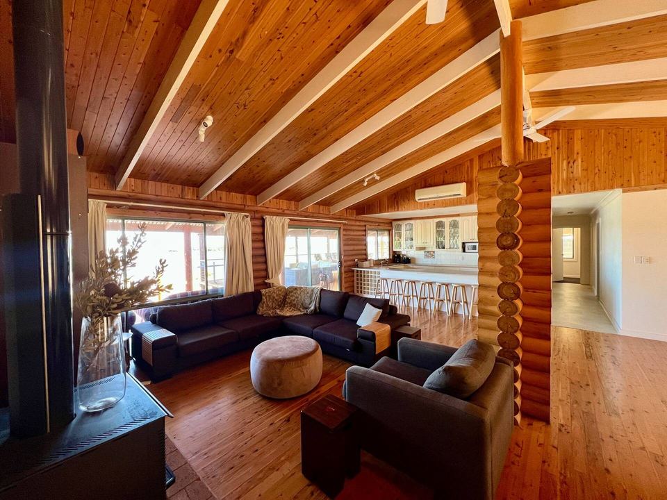 Timber-lined open-plan living room with lake views